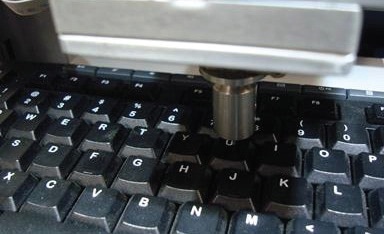 Close-up view of the test setup for force-displacement measurements on a keyboard.