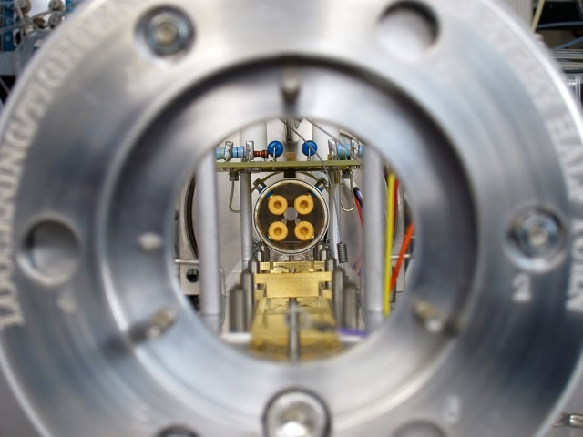 A view down the path charged analytes travel in a mass spectrometer. The quadrupole that separates the analytes in order of their mass can be seen in the distance.