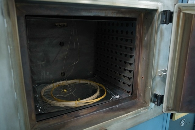 Testing scheme for elevated temperature cycling measurements showing placement of fiber optic coils in the furnace.