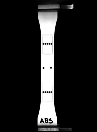 Image of sample with flags attached to mark the boundaries of the gage length.