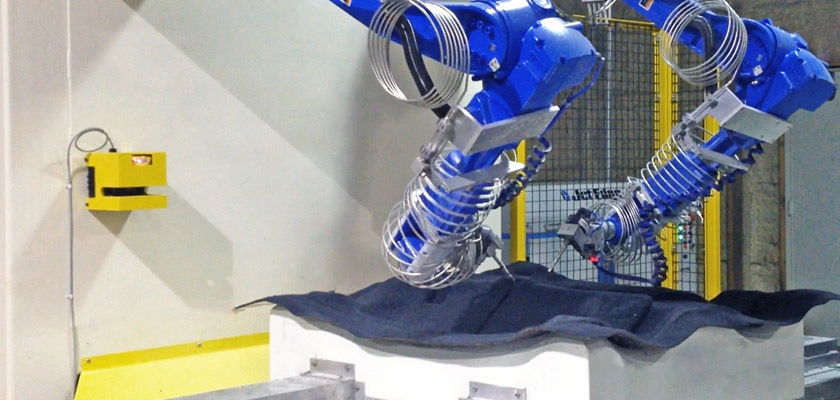 Alliance Automation’s 6-axis robotic waterjet trimming cell with dual wall-mounted Motoman HP20D robots powered by Jet Edge’s 60KSI (4100) bar iP60-50 intensifier.