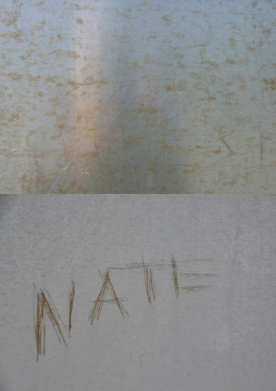 Two examples of corrosion: (Top) Discoloration in the form of superficial corrosion staining to the stainless steel surface. This is a typical condition at the base and lower reaches of the monument. (Bottom) Corrosion associated with incised graffiti. The discoloration is from the corrosion of iron particles left by the implement used to scratch the graffiti into the surface or penetration through the passive film into the base metal. This is also common at the lowest two panels on each leg of the monument.