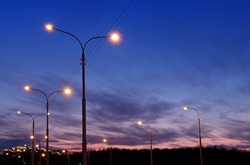 Rows of lit street lamps at dusk.