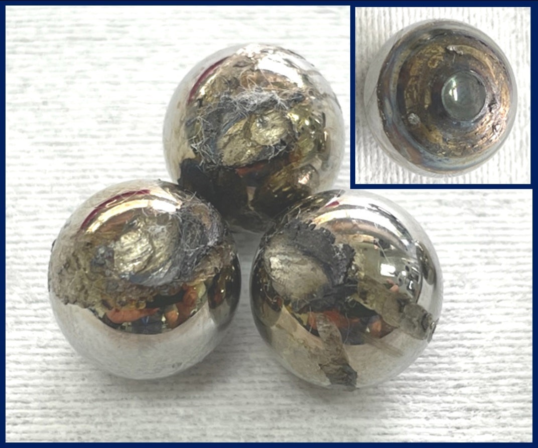 Severely damaged steel balls with signs of oxidation, slipping, and welding.