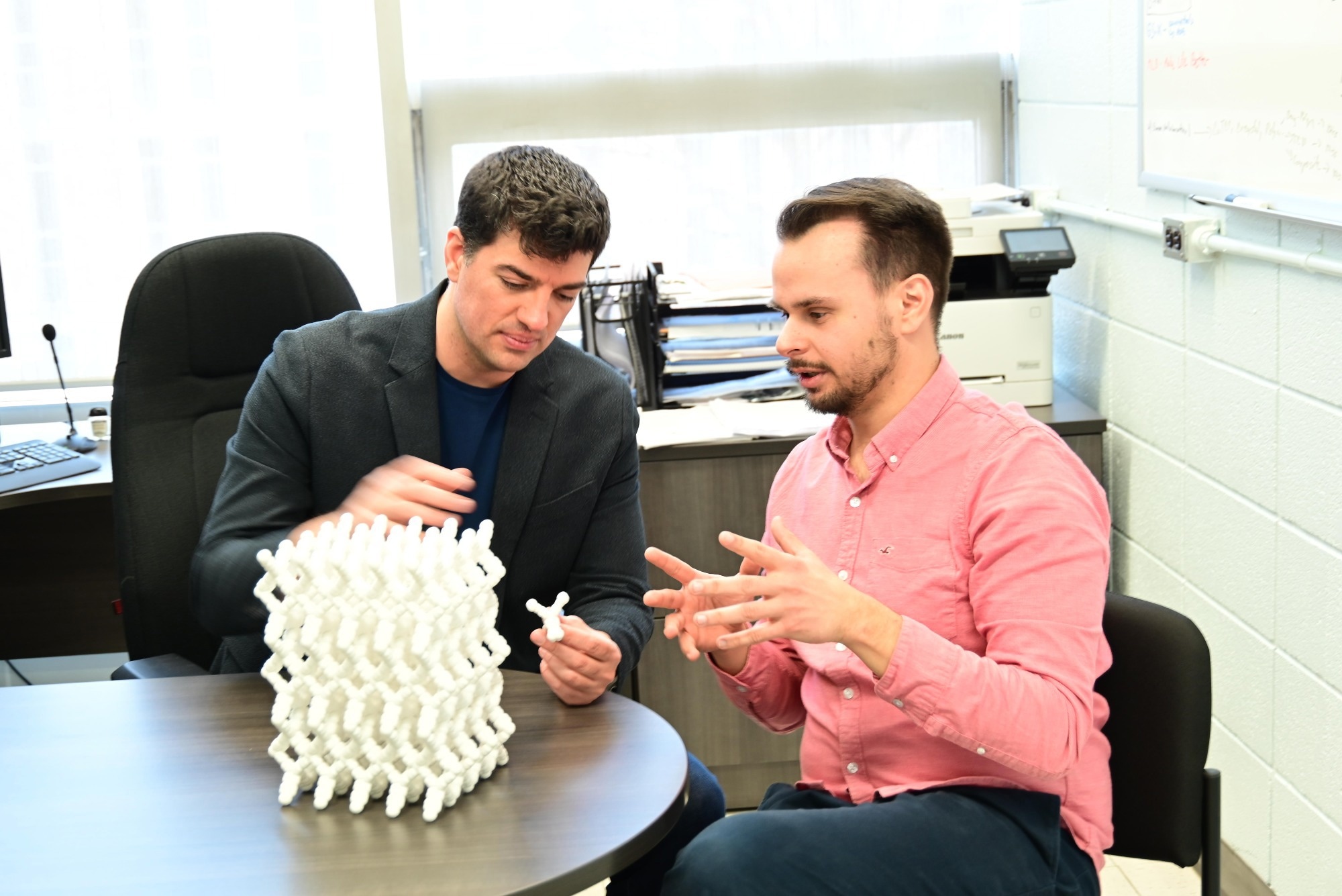 Prof. Nicholas Vukotic and Dr. Anton Dmitrienko examine a 3D-printed crystal structure at the University of Windsor as part of their crystal engineering research.