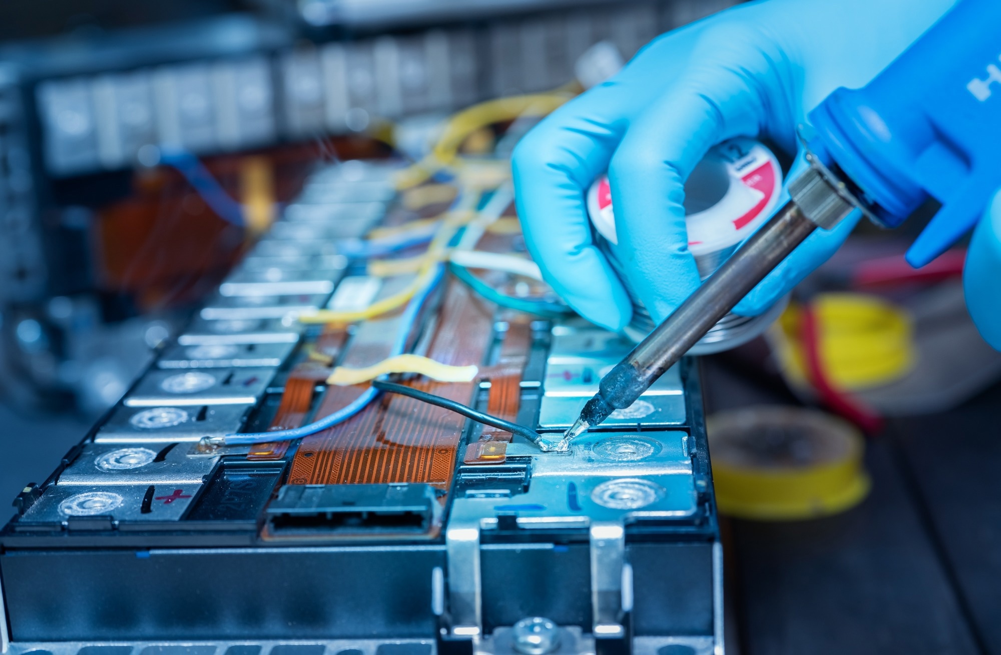 Technician use soldering iron to solder metal and wire of lithium-ion rechargeable battery.